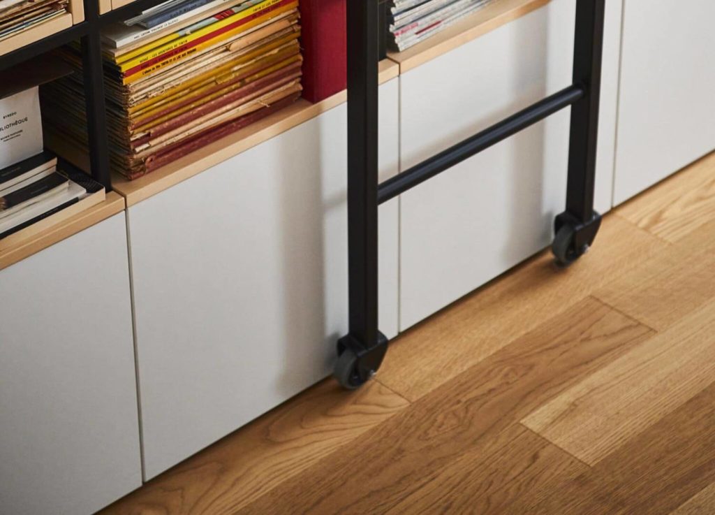 Grande bibliothèque sur mesure bois et métal à Paris 4e avec éclairage et échelle