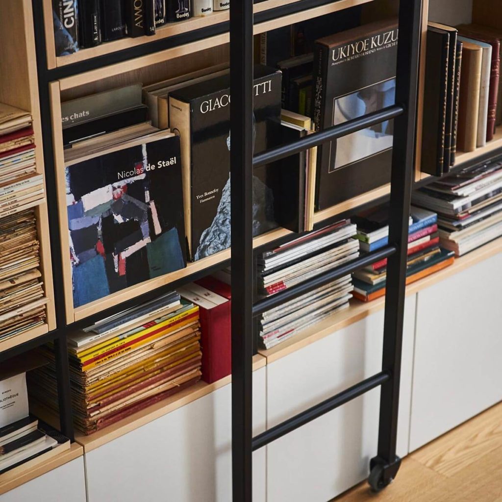 Grande bibliothèque sur mesure bois et métal à Paris 4e avec éclairage et échelle