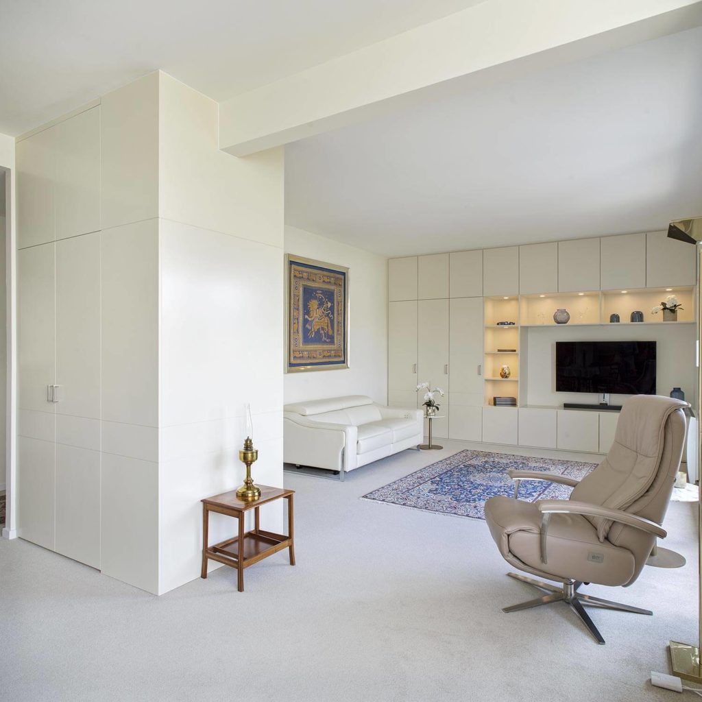 Meuble TV lumineux créé pour rénovation intérieure d'un salon blanc à Paris 16e